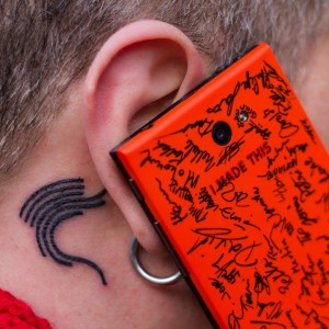Jollan Marc Dillon korvallaan erikoispuolikkaalla varustettu Jolla ja korvan takana tatuoituna Sailfish-logo. Kuva: Eric Le Roux.