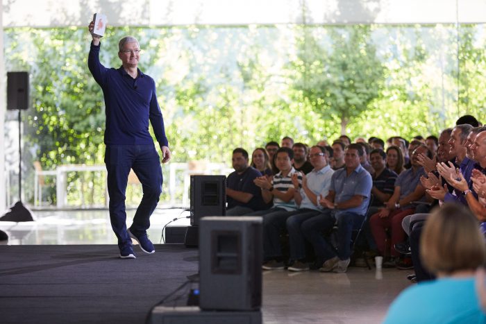 Tim Cook kädessään iPhone, jolla Apple ylitti miljardin rajan.