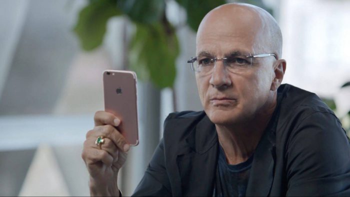 Applen musiikkipomo Jimmy Iovine pitää kädessään iPhonea, jonka kaltaista Apple ei ole julkistanut.