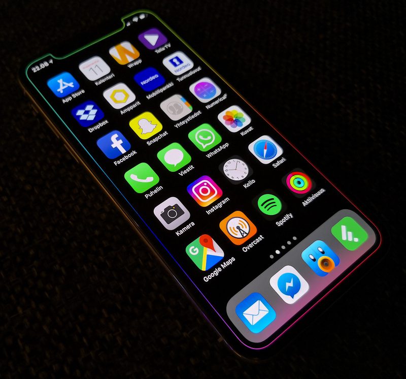 iPhone X:n näytön reunoja - mukaan lukien yläreunan lovi - liukuvärillä kiertävä, muuten musta taustakuva.