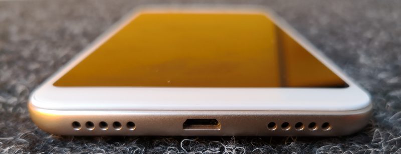 Pohjasta Xiaomi Redmi 5 Plussasta löytyy Micro-USB-liitäntä kaiuttimen ja mikrofonin aukkojen lisäksi.