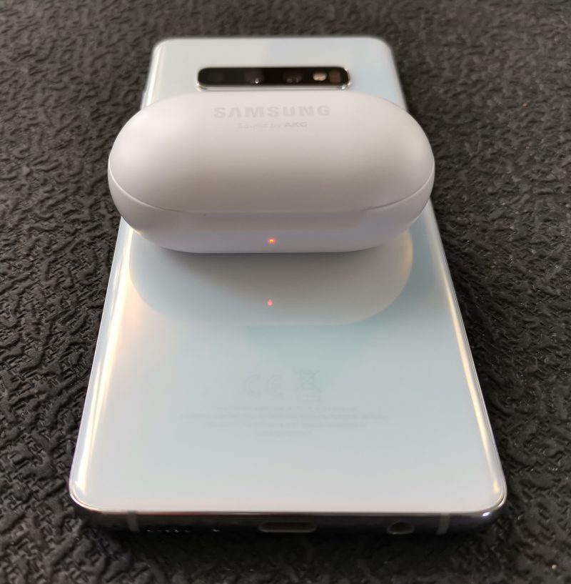 Galaxy S10 -puhelinten takapinnan päällä voi ladata langatonta latausta tukevia älypuhelimia tai Samsung-laitteita, kuten tässä Galaxy Buds -kuulokkeiden koteloa.