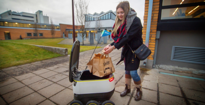Tallinnan teknillisen yliopiston opiskelija Diana Makhova ottaa vastaan yhden historian ensimmäisistä Wolt-robottikotiinkuljetuksista