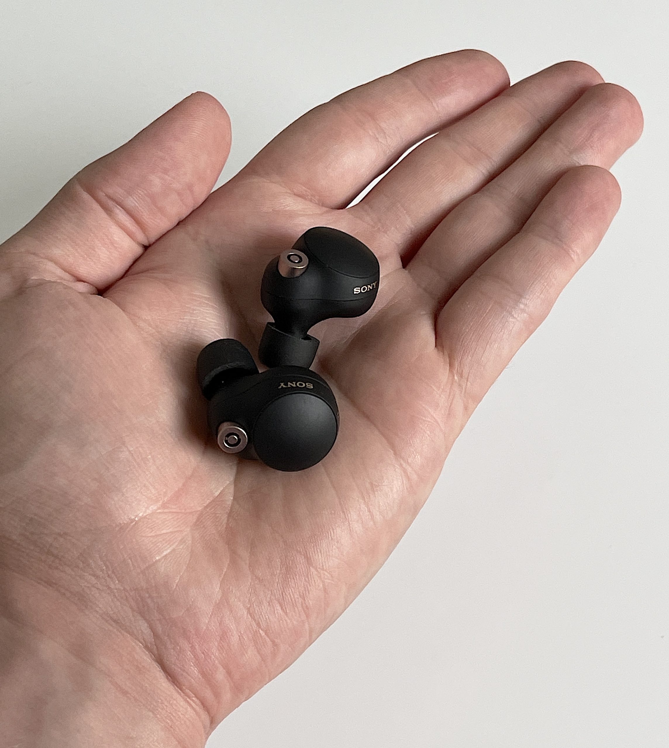 Sony WF-1000XM4-kuulokkeet kämmenellä. Kuulokkeiden koko kannattaa huomioida ennen ostopäätöstä.
