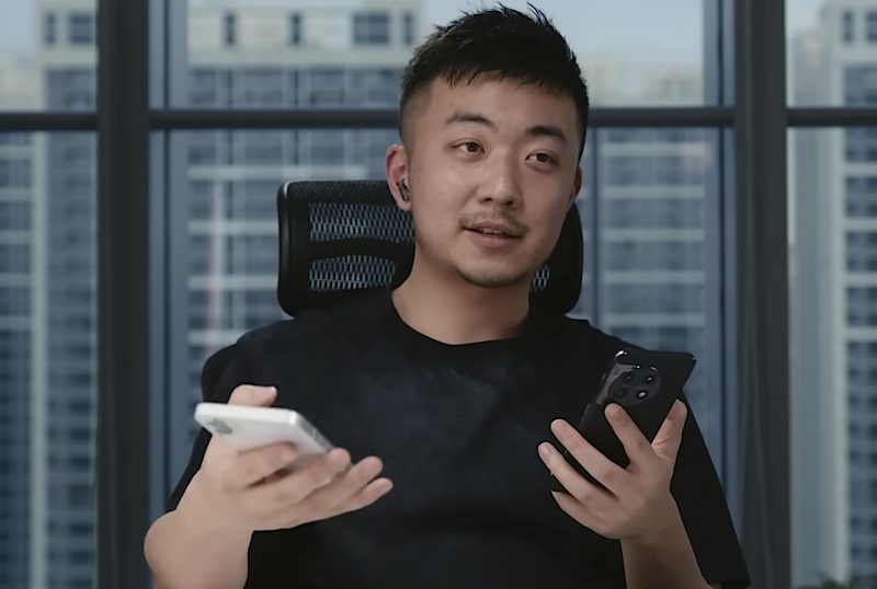 OnePlussan perustajajäsen ja Nothingin perustaja Carl Pei kädessään valkoinen Nothing Phone (1) ja musta OnePlus 11.