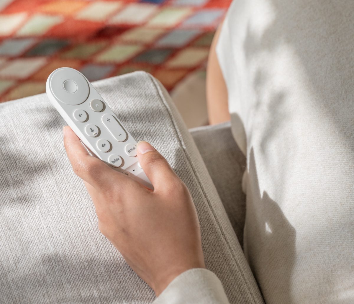 Google TV Streamer Voice Remote -kaukosäädin kädessä.