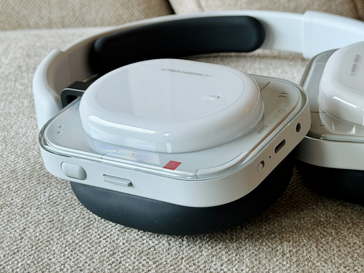 Fyysiset ohjaimet ovat Nothing Headphone (a):lle vahva valttikortti. Kuvassa näkyvät pyöritettävä rulla ja keinukytkin kuulokkeen sivulla sekä pohjassa liitäntöjen rinnalla virtakytkin.